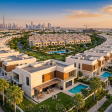 Aerial view of a mature Dubai villa and townhouse community at golden hour, with a family visible at a hero villa and the Dubai skyline in the distance — a 2026 buyer's guide.